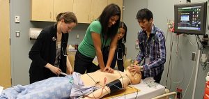 Students trying to resuscitate SimMan 3G in the Pritchard Simulation Centre.