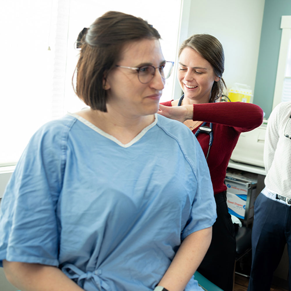 SMP student Kara Ruff examines a volunteer patient alongside Dr. Marjorie Docherty, Family Practice Lead for SMP, and SMP classmate Dylan Nemes.